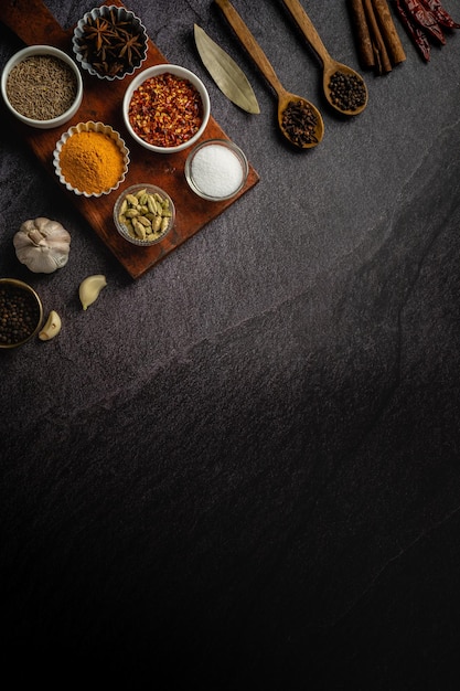 Bowls with spices on dark background