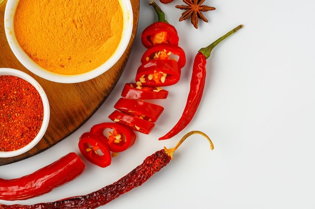 Bowls with spices on wooden board on white background