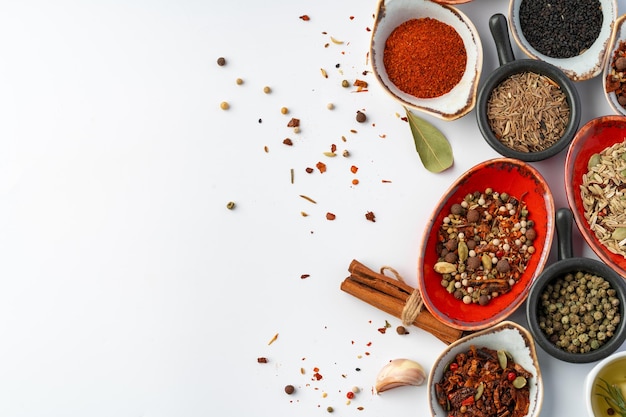 Bowls with various spices on white background