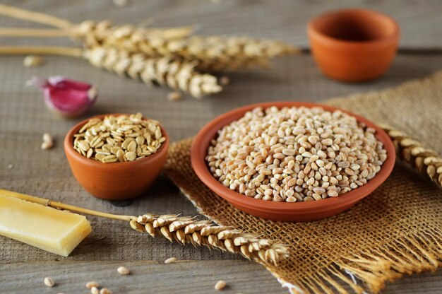 Foto ciotole con chicchi di grano su sfondo chiaro chicco di grano fresco sul tavolo