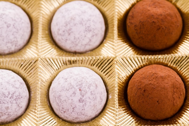 Box of assorted gourmet truffles on a white background.