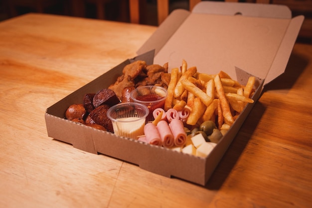 Box of assorted snacks with toppings on a wooden table