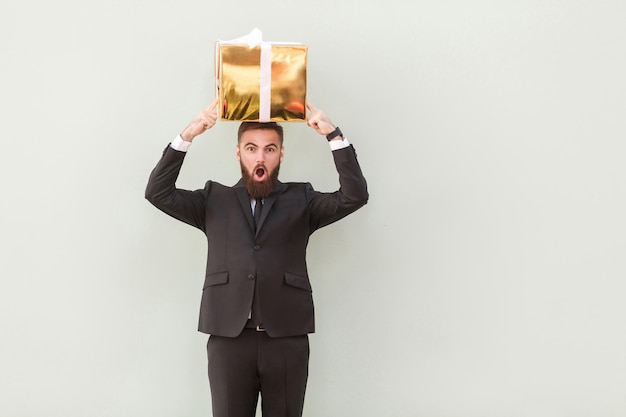 The box balances on the head a amazed businessman