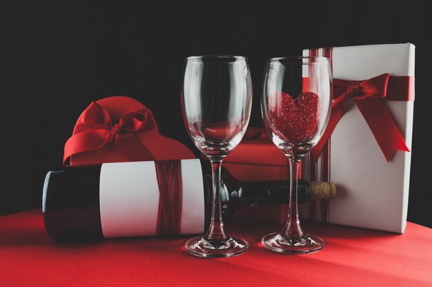 Photo box of chocolates with a bottle of wine and two glasses one with a heart