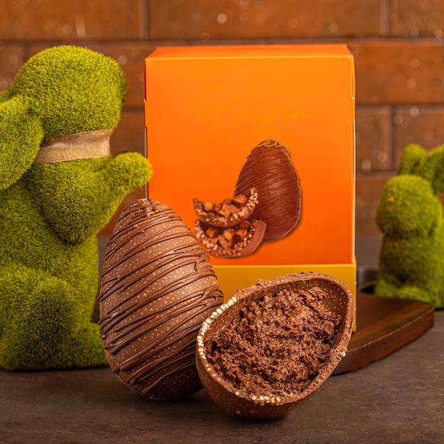 A box of chocolates with a turtle looking at a chocolate egg.