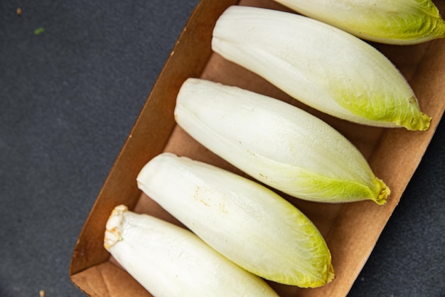 A box of cucumbers sits on a dark surface