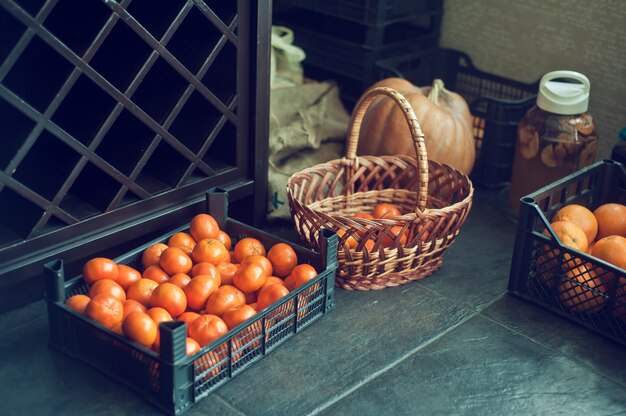 Box of fresh clementines, pumpkin and other fruits on vegan kitchen