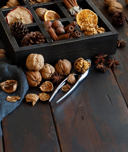 A box full of spices and nuts on a wooden table close up