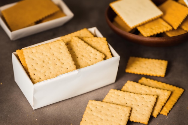 A box of graham crackers with a bowl of graham crackers on the side.