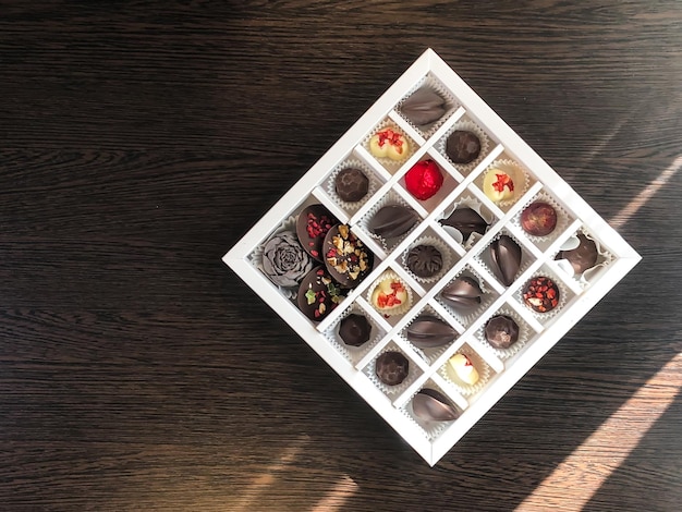 Photo a box of handmade chocolates of different colors