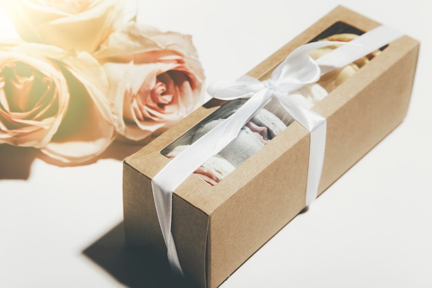 Photo box of macaroons and flowers on a white background