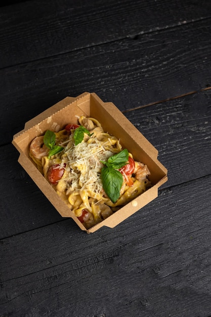 A box of pasta with tomato sauce and cheese