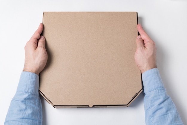 Box of pizza in male hands. Concept of food delivery to home.