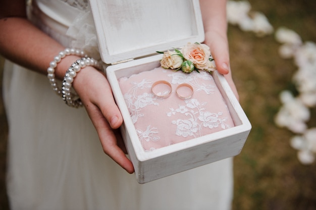 A box for rings in the hands of a girl. Wedding details.