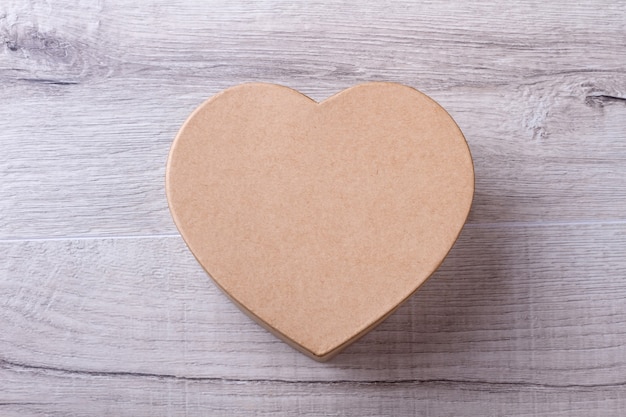 Box in shape of heart. Gift box on wooden background. Top view of present box. Best gift in February.