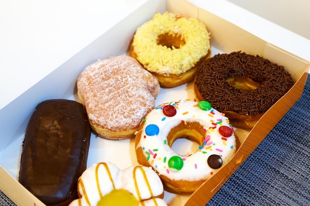 Box of sweets filled with colorful donuts and eclairs