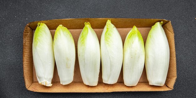 A box of white flowers with green leaves on the top