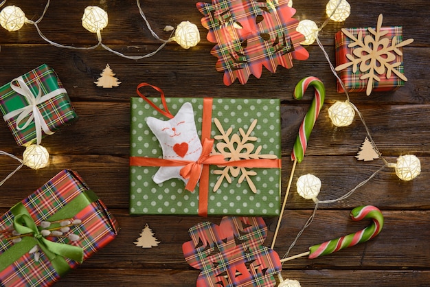 Box with Christmas gift decorated with handmade toys of cat on the wooden table