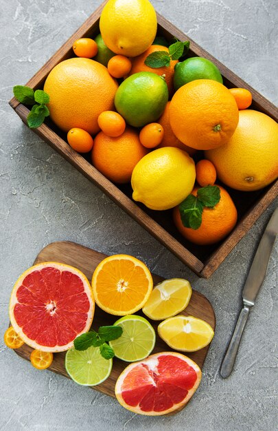 Box with citrus fresh fruits on a concrete background