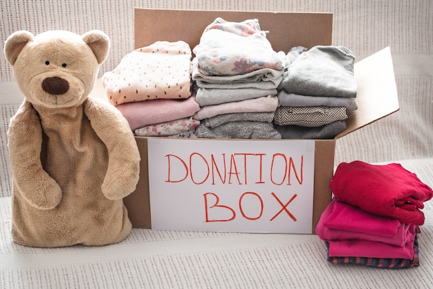 Box with clothes for charity and teddy bear