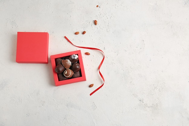 Box with delicious chocolate candies on light