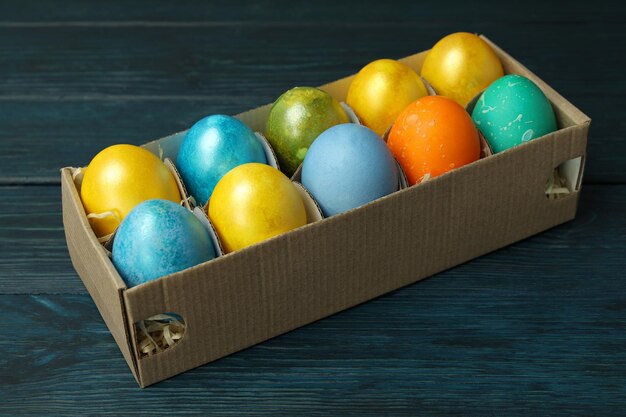 Box with Easter eggs on wooden background close up