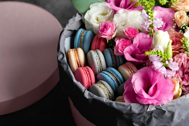 Box with fresh flowers and macaroons closeup