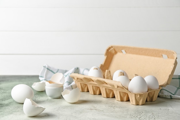 Box with fresh raw eggs on table