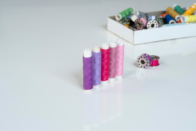 Photo box with multi-colored spools and bobbins of thread for sewing