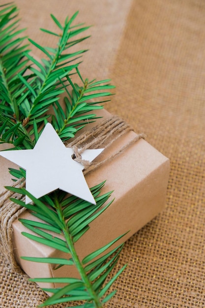 Box with new year\'s gifts wrapped in craft paper and decorated\
with fir branch holidays and gifts concept handmade eco friendly\
alternative green christmas presents zero waste