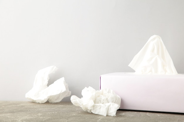 Box with paper tissues and used crumpled napkins