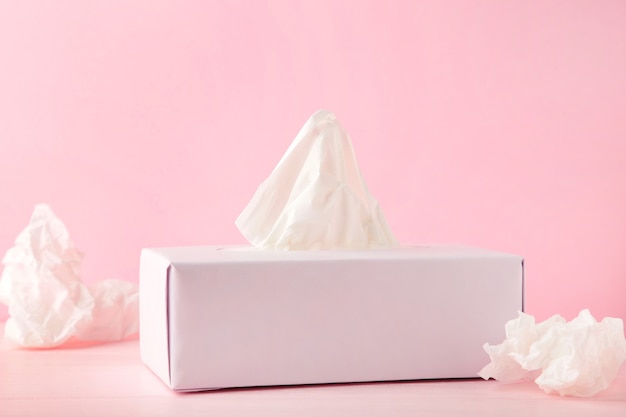 Box with paper tissues and used crumpled napkins