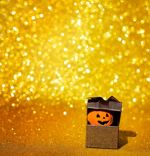 box with peeking pumpkin on glitter background