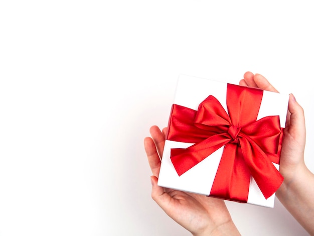 A box with a red bow in its hands The concept of congratulations a gift