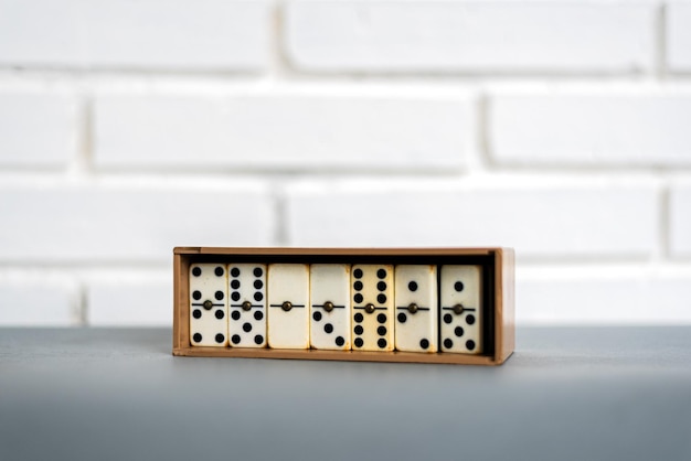 Box with retro dominoes on table