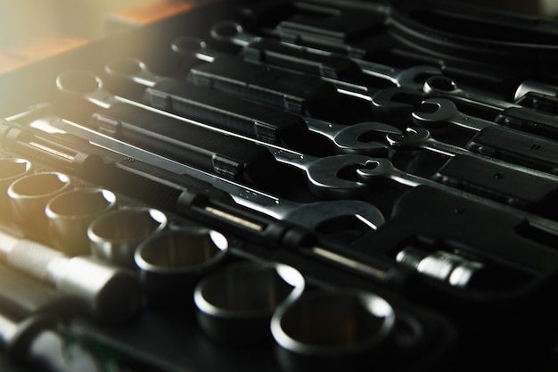 Box with set of tools for car repair, close-up, low key with lens glare.