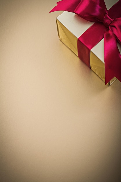 Boxed gift met gebonden strik op gouden achtergrond vakantie concept