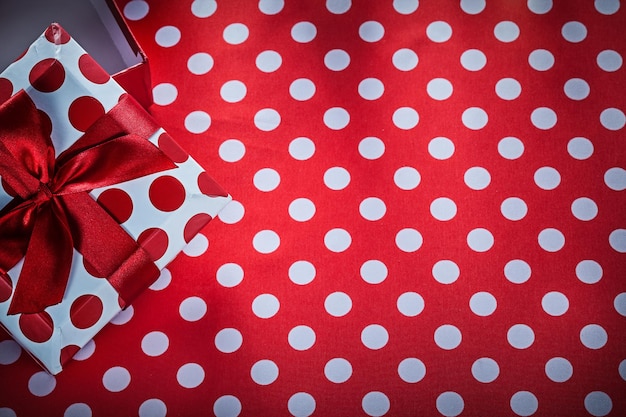 Boxed present on polkadot red textile celebrations concept