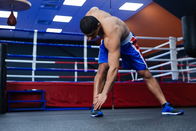 Boxer doing warm up exercises near boxing ring