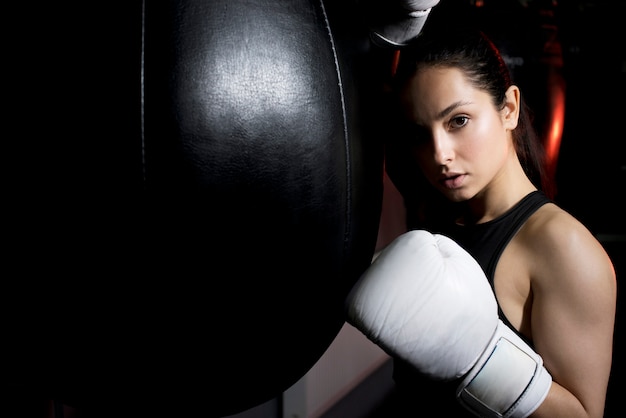 Foto ragazza del pugile che posa in palestra