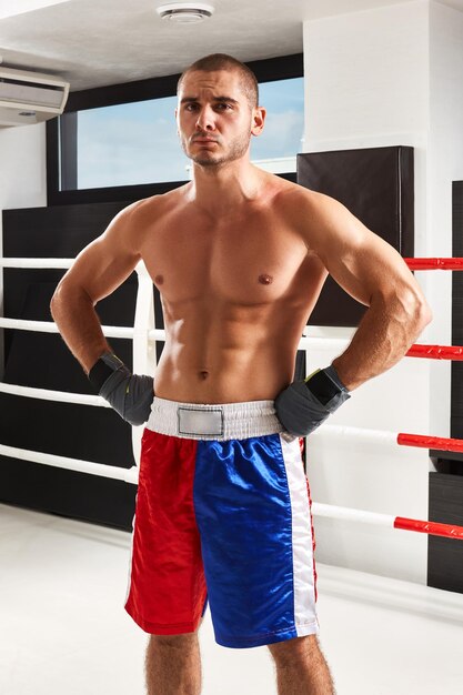 Boxer in blauwe handschoenen aan het opwarmen in de sportschool