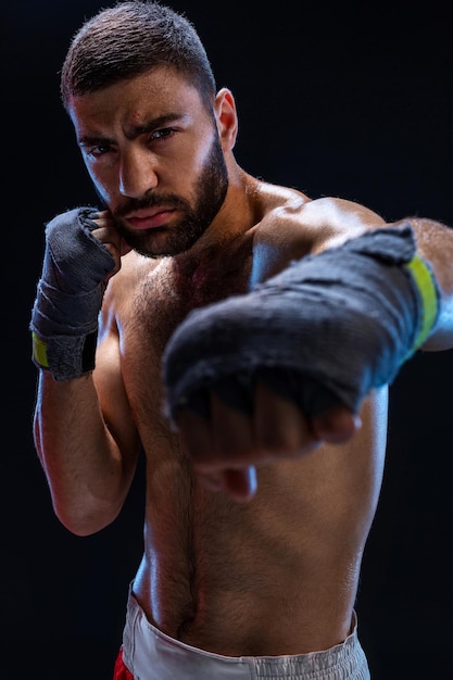 권투 선수는 강한 손과 꽉 쥔 주먹으로 근육질의 남자의 강력한 타격 사진을 처리 할 준비가되어 있습니다 ...