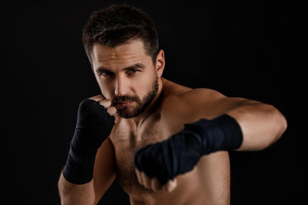 Boxer man toont de verschillende bewegingen op zwarte achtergrond