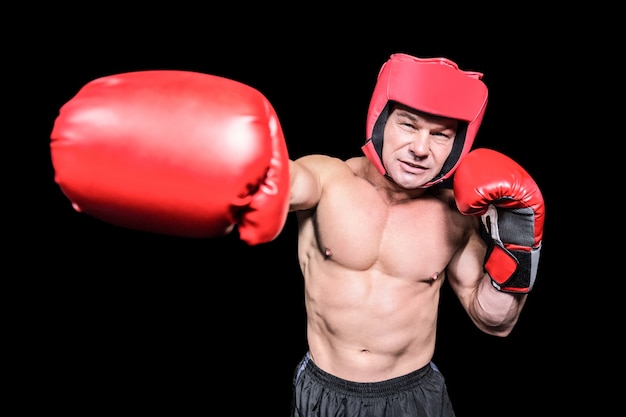 Boxer punching against black background