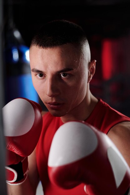 Photo boxer standing in front of punching bag