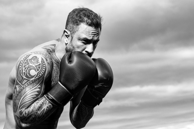 Boxer formazione all'aperto pugile maschio formazione difesa e attacchi in guantoni da boxe pugilato pugno