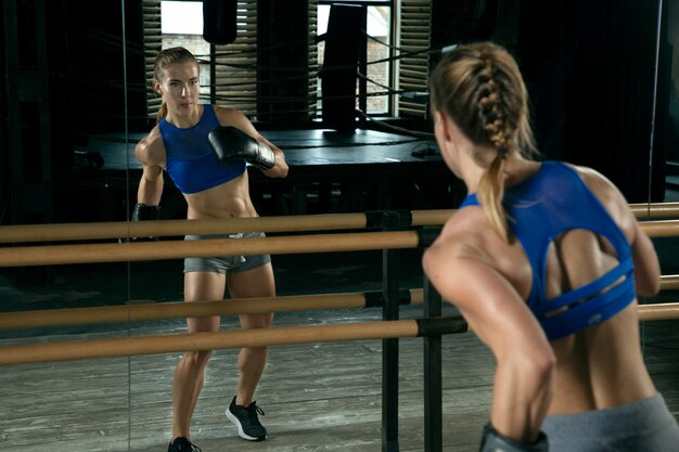 Boxer woman training in front of mirror