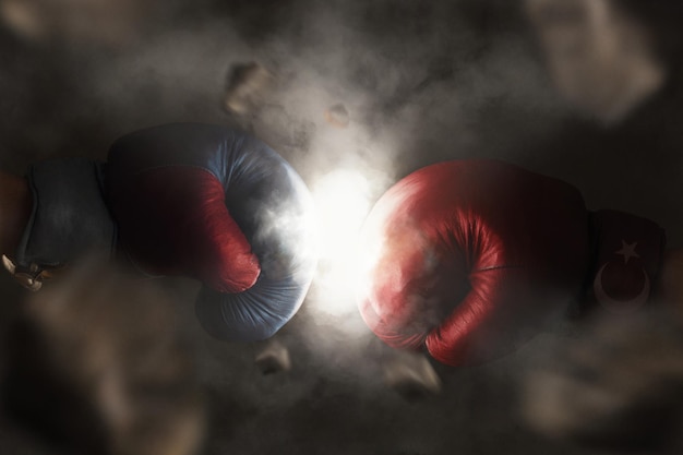 Boxers wearing boxing gloves touching over black background