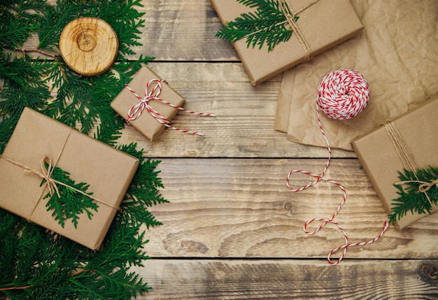 Boxes packed in kraft paper and green branches on a wooden background. Sale.Christmas and New Year.