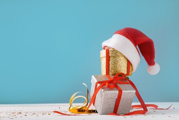 Boxes with Christmas presents with Santa hat on top